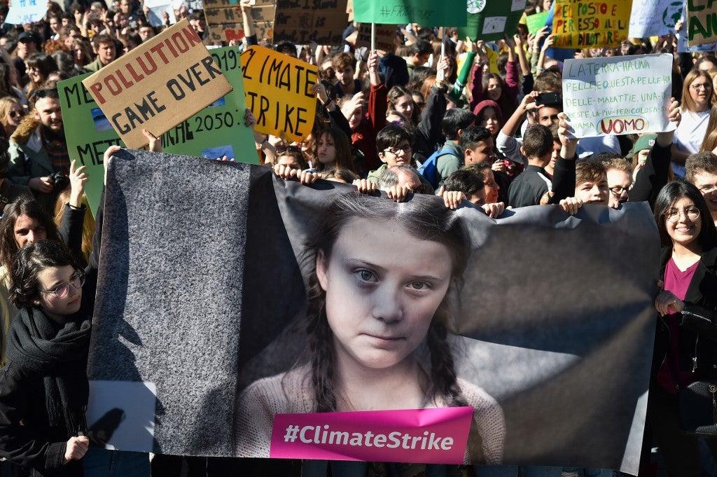 Des étudiants tiennent des pancartes et une bannière montrant Greta Thunberg lors d'une manifestation contre le réchauffement climatique dans le centre de Rome, le 15 Mars, 2019. Andreas SOLARO/AFP