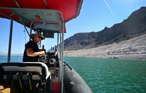 Boat operator Brian Essex navigates his boat on Lake Mead near the Hoover Dam — Frederic J. BROWN / AFP