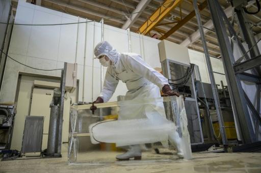 Un travailleur déplace de la glace au sein de l'usine Kuramoto Ice à Kanazawa, au Japon, le 15 juin 2026 — Yuichi YAMAZAKI / AFP