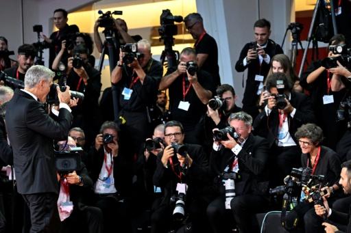 O ator e cineasta americano George Clooney fotografa a fotógrafa da AFP Tiziana Fabi após a cerimônia de abertura da 83ª edição do Festival Internacional de Cinema de Veneza, em 2 de setembro de 2026 — ANDREA PATTARO / AFP