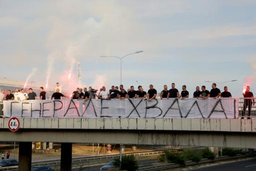 Des personnes rassemblées sur une passerelle d'autoroute tiennent une banderole "Merci, Général", avant le passage du convoi transportant la dépouille du criminel de guerre serbe de Bosnie Ratko Mladić à Belgrade, en Serbie, le 3 septembre 2026 — Pedja MILOSAVLJEVIC / AFP