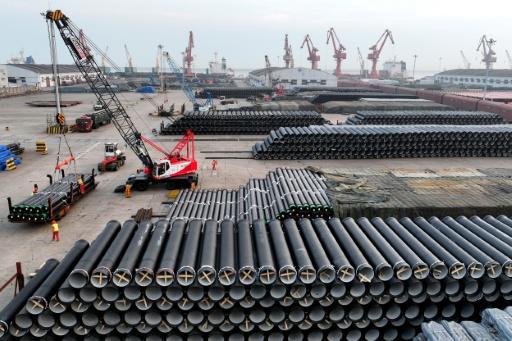 Unos trabajadores cargan tuberías de acero en un barco para su exportación, el 27 de marzo de 2026 en un puerto de Lianyungang, provincia de Jiangsu, al este de China — - / AFP