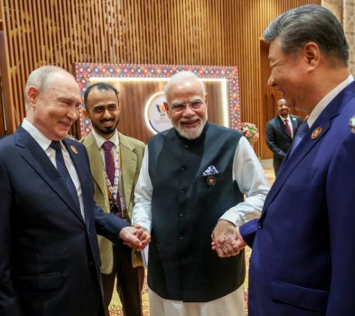 primer ministro indio, Narendra Modi, da la mano al presidente ruso, Vladimir Putin (izq), y al presidente chino, Xi Jinping (dcha), durante la última cumbre de los BRICS, el 12 de septiembre de 2026 en Nueva Delhi — . / AFP