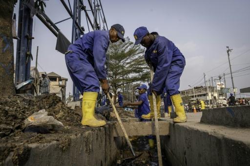 D'anciens membres de "kulunas", des gangs de jeunes, effectuant désormais leur service national, nettoient les égouts avant la saison des pluies à Kinshasa, capitale de la République démocratique du Congo, le 1er septembre 2026 — GLODY MURHABAZI / AFP