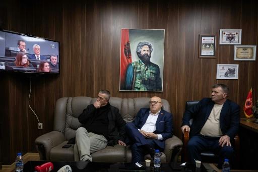 Kosovo Liberation Army veterans watch the Hague trial on a television in Pristina on February 9, 2026.  In Kosovo, where former guerrilla leaders are still celebrated as heroes, the war crimes trial of ex-president Hashim Thaci and other senior commanders has reignited bitter debate over the legacy of the independence struggle.The trial in The Hague, which hears closing statements this week, involves former President Hashim Thaci and three other men who were senior figures in the Kosovo Liberation Army (KLA