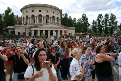 Des fans de la chanteuse canadienne Céline Dion chantent lors d'un "Karaoké géant" organisé en son honneur devant le monument de la Rotonde Stalingrad à Paris, le 11 septembre 2026 — Anne-Christine POUJOULAT / AFP