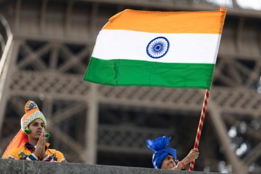 Des membres de la communauté hindoue Bochasanwasi Akshar Purushottam Swaminarayan Sanstha (BAPS) agitent des drapeaux indiens lors d'une cérémonie religieuse devant la tour Eiffel, avant un défilé fluvial sur la Seine à Paris, le 3 septembre 2026 — Kenzo TRIBOUILLARD / AFP
