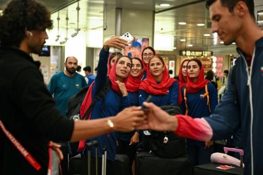 Members of the Iranian team take a selfie as they arrive for the 2026 Asian Games — Mohd RASFAN / AFP