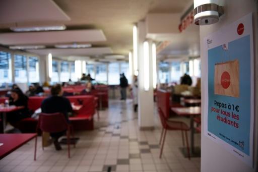 People are having lunch at a Crous (Centre régional des oeuvres universitaires et scolaires) restaurant where one euro meal are served for students on February 9, 2021 in Paris. — Martin BUREAU / AFP