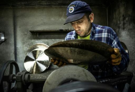 Un employé travaille sur une cymbale dans un atelier à Istanbul, le 30 juillet 2026 — Ozan KOSE / AFP