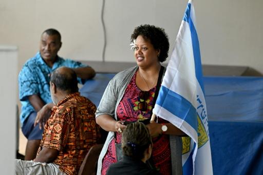 A Fijian woman waves the flag of Jerusalem during the nation's general election in 2022. — SAEED KHAN / AFP