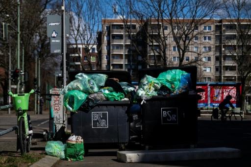 Overflowing garbage containers outside a Berlin residential building in March 2025 following a week-long warning strike by the city's waste management service — John MACDOUGALL / AFP