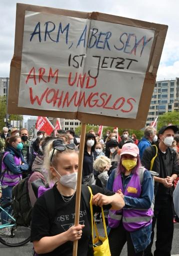 A protester holds a sign reading 'Poor but Sexy now is Poor and Homeless' during a rally against soaring rents in Berlin — John MACDOUGALL / AFP
