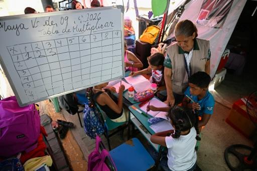 Students attend classes inside a temporary tent classroom on the first day of the new school year in La Guaira, Venezuela, which was hit hard by earthquakes in June — Federico PARRA / AFP