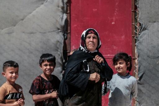 Una mujer kurda siria desplazada, originaria de la ciudad de Ras al-Aín, con niños en el campo de desplazados de al-Talaeh, en Hasaké, en el noreste de Siria, el 23 de julio de 2026 — Delil SOULEIMAN / AFP