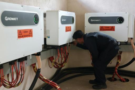Senior engineer Rinzin Galley checks solar inverters in a control room at the Norion Renewable Energy company compound in Bhutan's capital city of Thimphu — Niharika KULKARNI / AFP