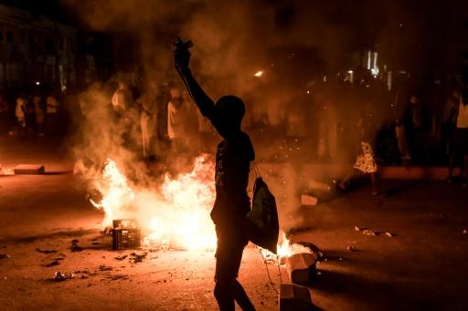 Un manifestant se tient près d'une barricade lors d'un rassemblement spontané à Brusubi en Gambie le 8 septembre 2026, pour protester contre des semaines de coupures d'électricité prolongées dans le pays  — Muhamadou BITTAYE / AFP